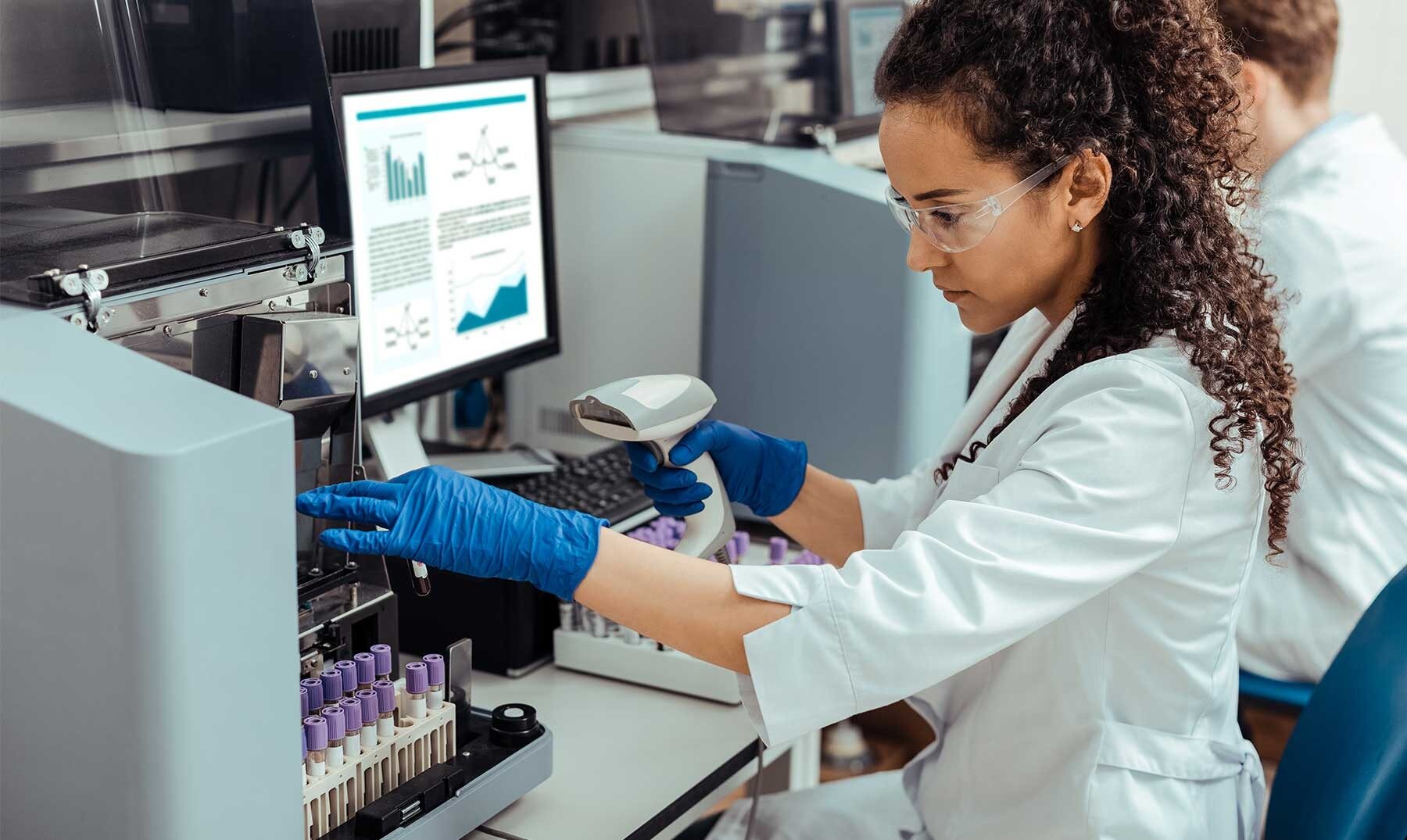 Laboratory Management Services for Clinical Labs woman working on her computer in a laboratory facility