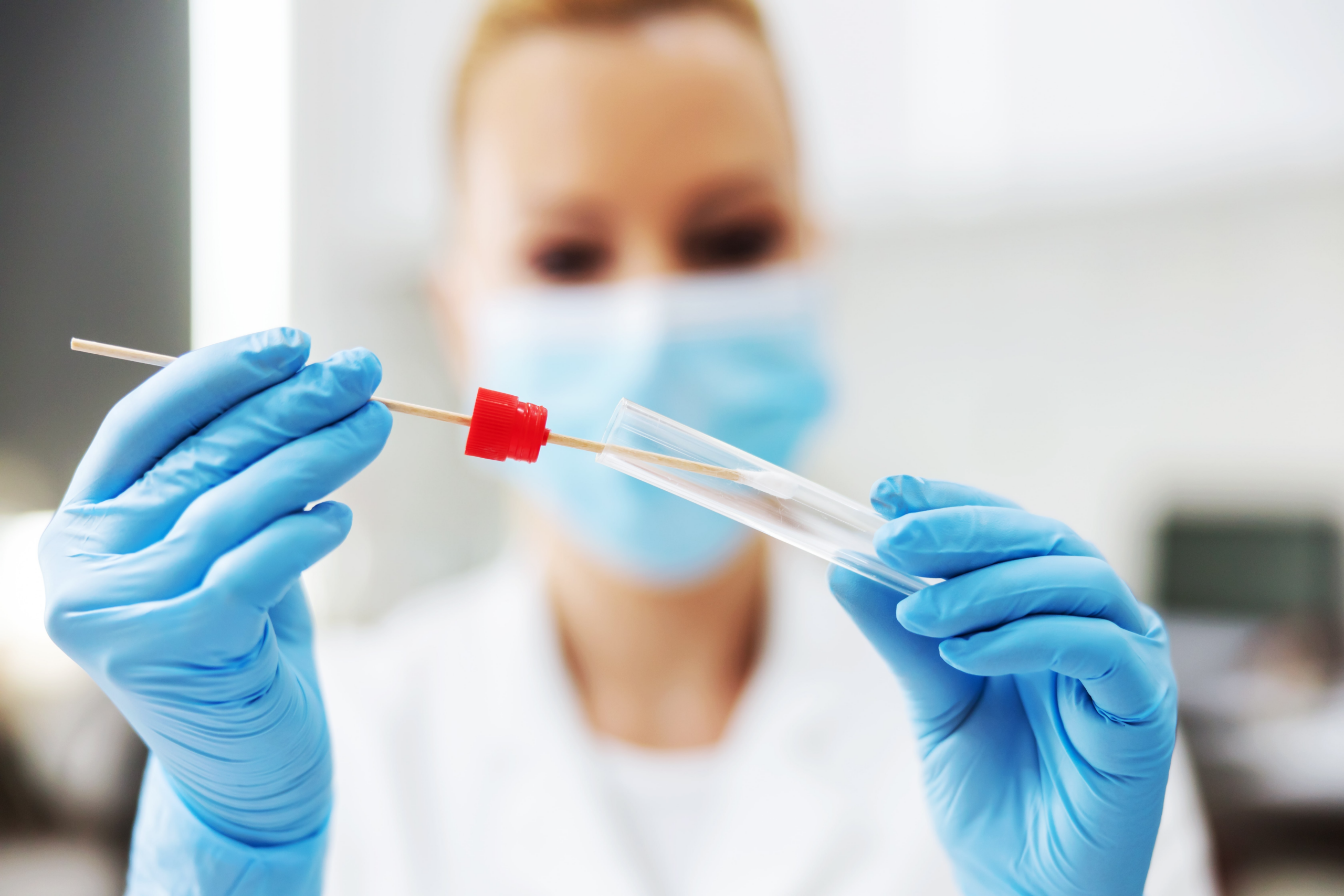 woman in laboratory with gloves and PCR test