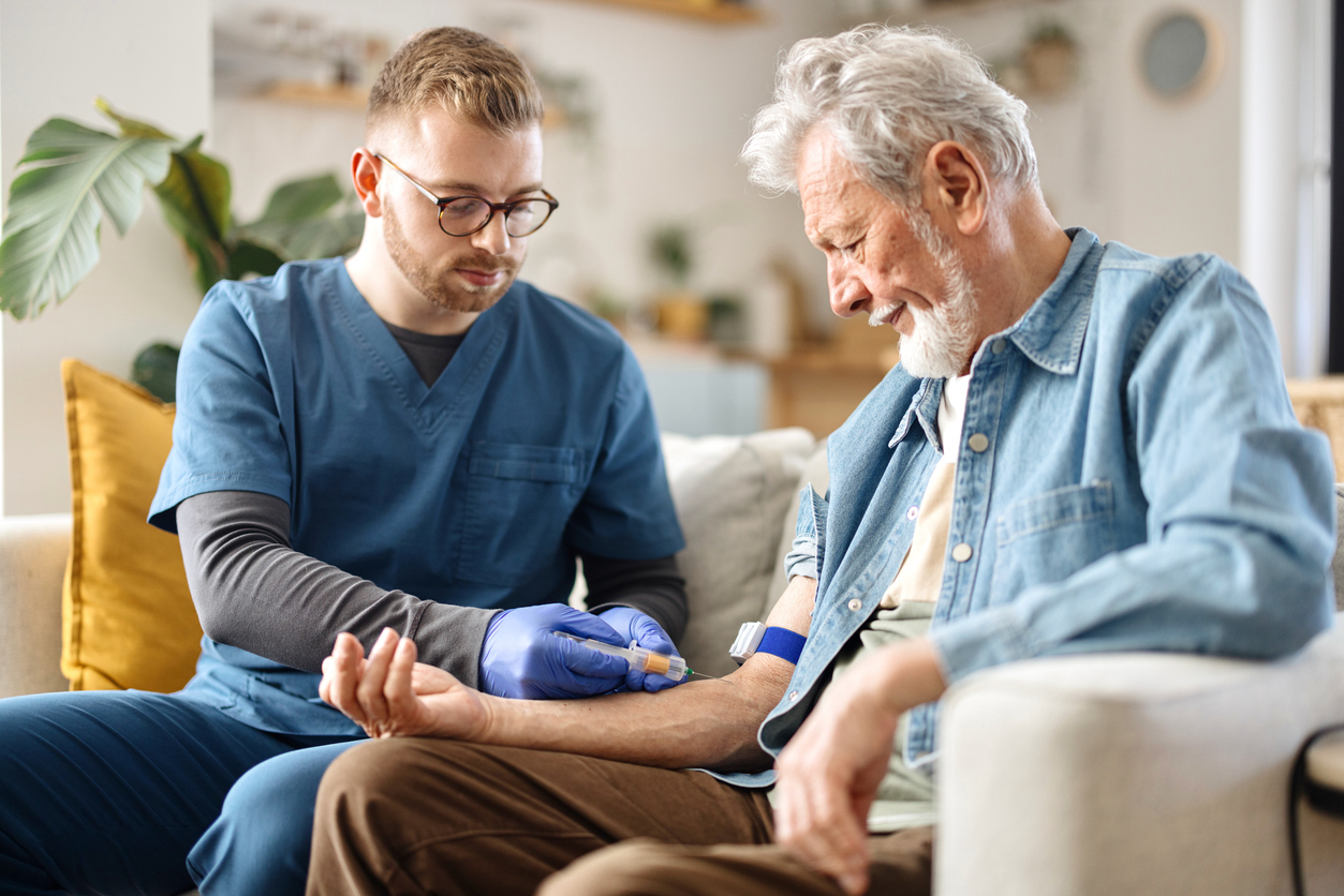 Male nurse draws blood from a senior patient A doctor draws blood from an elderly patient.
