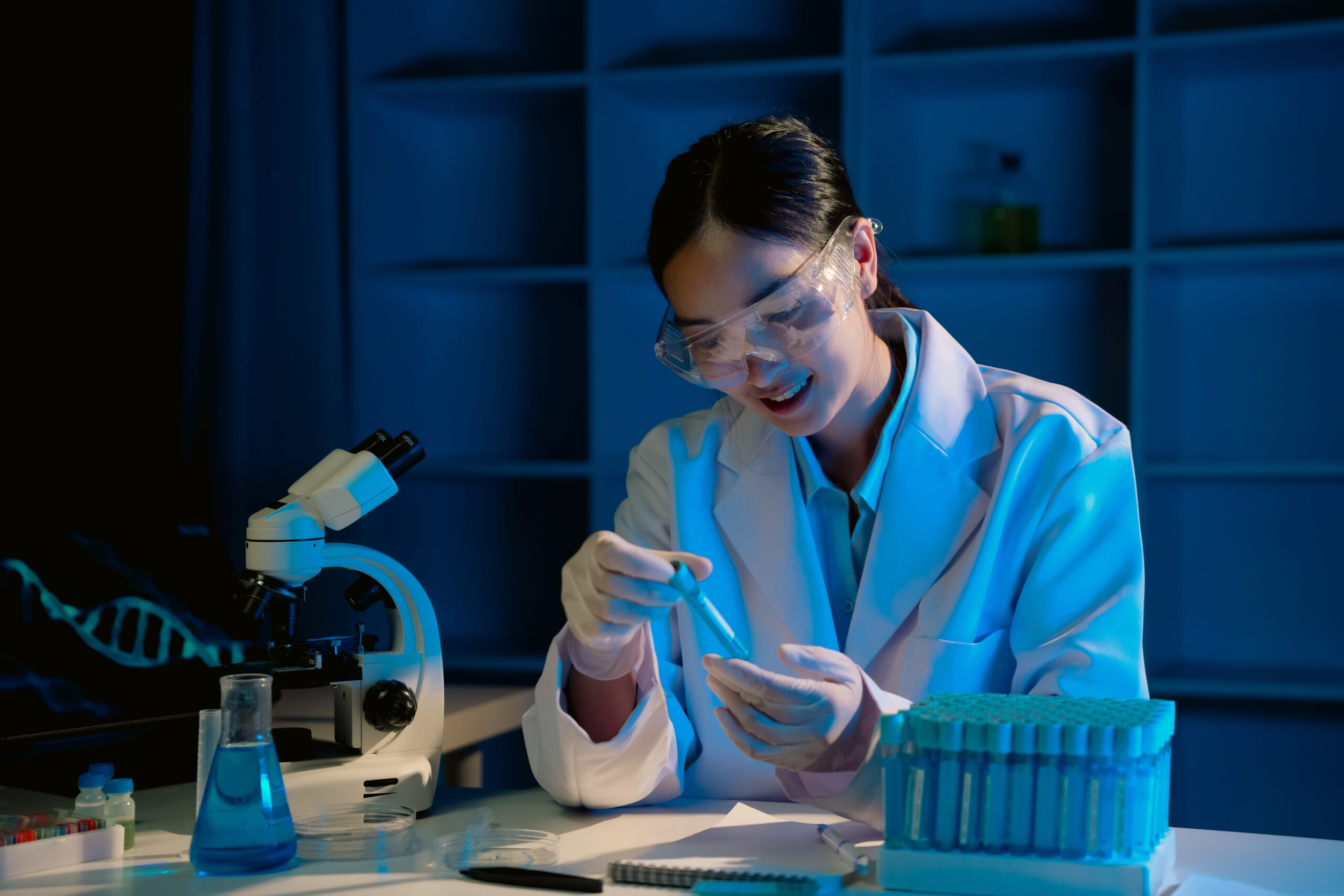 Scientist conducting medical experiment in laboratory with scientific equipment and safety gear Scientist is working on a medical experiment in a laboratory setting, surrounded by scientific equipment and wearing a lab coat and safety glasses
